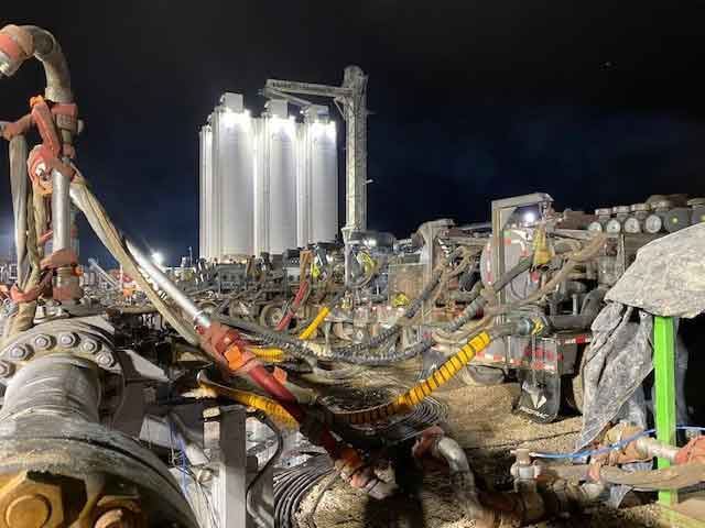 Fleet of rental equipment on job site - vacuum trailers, containment systems, light towers